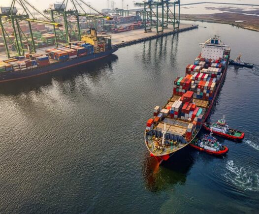 red and blue cargo ship on body of water during daytime